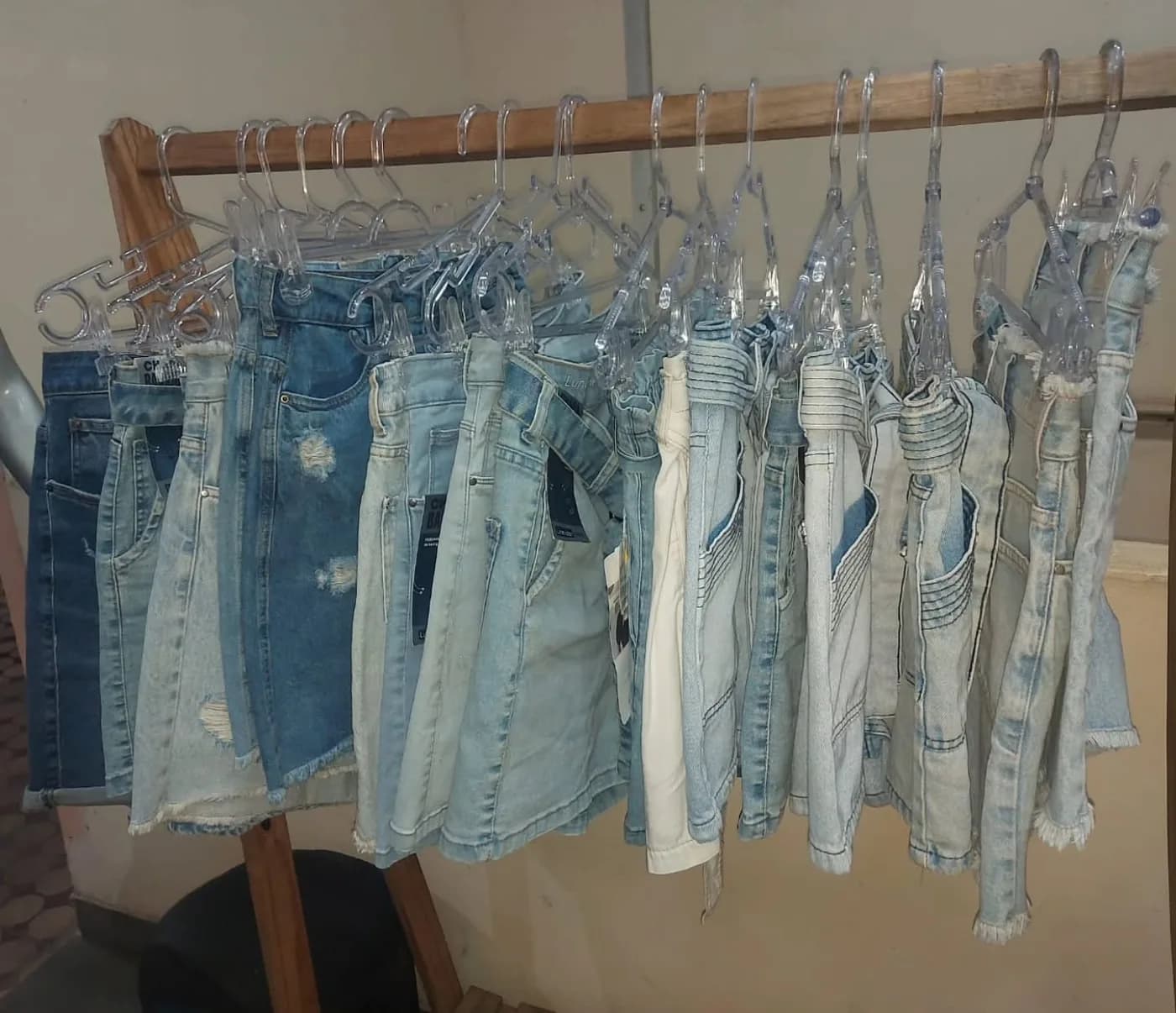 A arara de shorts jeans da OFF, do claro ao escuro, nos cabides transparentes